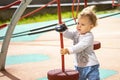 Toddler 1 year girl boy Caucasian, child play on the playground, baby with wavy hair in the wind, horizontal summer Royalty Free Stock Photo