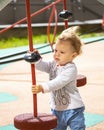 Toddler 1 year old girl boy Caucasian, playing on playground, baby with wavy blonde hair in the wind Royalty Free Stock Photo