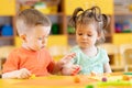 Toddlers boy and girl playing at table with educational toys. Children infants at home or daycare. Royalty Free Stock Photo