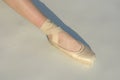 Toe dancing. Ballerina leg in white ballet shoe. Lacing ballet slipper. Female foott in pointe shoe. Pointe shoe worn by