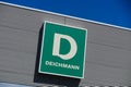TOENISVORST, GERMANY - JUIN 28. 2019: Close up of green logo against blue sky on metal wall of Deichmann german chain for shoe