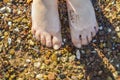 Toes in the water with pebbles