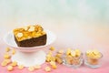 Toffee chocolate cake slice on high plate at left side of frame and nut seeds in tow bowls on colorful background for dessert