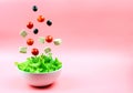 Tofu cheese, cherry tomatoes and olives flying out of the white bowl on a pink background. Concept of a healthy diet. Royalty Free Stock Photo