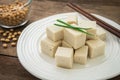 Tofu cubes on plate and soy beans in bowl Royalty Free Stock Photo