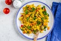 Tofu scramble with vegetables in a white plate, top view. Vegan Alternative fried eggs Royalty Free Stock Photo