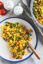 Tofu scramble with vegetables in a white plate, top view. Vegan Alternative fried eggs