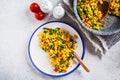 Tofu scramble with vegetables in a white plate, top view. Vegan Alternative fried eggs Royalty Free Stock Photo