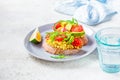 Tofu scrambled sandwich with avocado, arugula and tomato on gray plate. Healthy vegan food concept