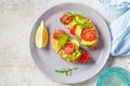 Tofu scrambled sandwich with avocado, arugula and tomato on gray plate, top view. Healthy vegan food concept