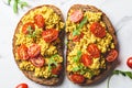 Tofu scrambled toast with tomatoes and arugula, white marble background. Plant based diet concept