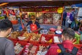 A tofu seller at the street fresh market Putrajaya, Kuala Lumpur. Customers wait for the seller to pack their goods. Man with face