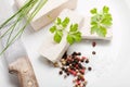 Tofu slices with parsley, salt, pepper and old knife on white background Royalty Free Stock Photo