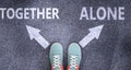 Together and alone as different choices in life - pictured as words Together, alone on a road to symbolize making decision and