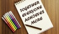 Together Everyone Achieves More. your future target searching, a marker, pen, three colored pencils and a notebook for writing