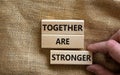 Together are stronger symbol. Concept words `Together are stronger` on wooden blocks on a beautiful canvas background. Businessm