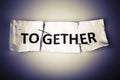 Together word on torn paper stapled back Royalty Free Stock Photo