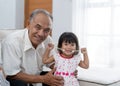 Togetherness of a grandfather with her little princess holding music instrument look at the camera Royalty Free Stock Photo