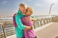 Togetherness. Happy mature family couple in sportswear embracing after having workout in the city park on a sunny Royalty Free Stock Photo