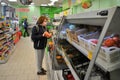 Red-haired girl in a medical mask chooses fruits at the grocery store.