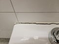 toilet in bathroom with crack in the wall or caulk