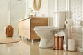 Toilet bowl near wooden screen in modern interior