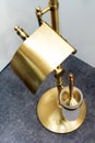 Toilet brush in retro style. Fragment of the interior of the restroom with golden elements. Close-up