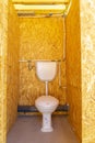 toilet and cistern inside a public bathroom built in chipboard or plywood installed Royalty Free Stock Photo