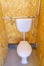 toilet and cistern inside a public bathroom built in chipboard Royalty Free Stock Photo