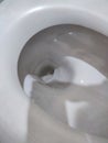 Toilet, Flushing Water, close up illuminated by artificial light Royalty Free Stock Photo