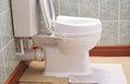 Toilet with height extension for disabled senior person indoors in house