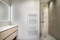 Toilet with open shower, white radiator, cabinet