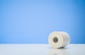 Toilet paper isolated on white table with blue background Royalty Free Stock Photo