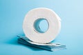 toilet paper roll and stack of dollars blue background copy space