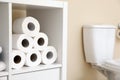 Toilet paper rolls on cabinet shelf