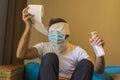 Crazy man in protective mask in home lockdown with head wrapped in tissue paper roll during coronavirus Royalty Free Stock Photo