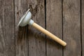 Toilet rubber plug with wooden handle for pipe cleaning on wooden background close up Royalty Free Stock Photo