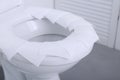 Toilet seat with paper tissues in bathroom Royalty Free Stock Photo