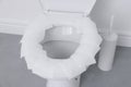 Toilet seat with paper tissues in bathroom Royalty Free Stock Photo