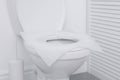 Toilet seat with paper tissues in bathroom Royalty Free Stock Photo