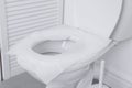 Toilet seat with paper tissues in bathroom Royalty Free Stock Photo