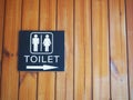 Toilet sign with wood background.