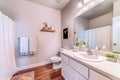 Toilet beside vanity unit with sink mirror and white cabinets inside bathroom Royalty Free Stock Photo