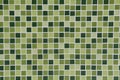 Toilet Wall of made of different hues in green tiles.