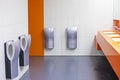 toilet with washbasins, hand dryers in a supermarket in orange colors