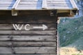 Toilet WC sign and arrow pointing right, on a wooden mountain hut Royalty Free Stock Photo