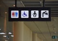 Toilets disabled symbol, drinking water, baby diaper table changing station, signs in departure hall Royalty Free Stock Photo