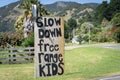 Informal road sign asking vehicles to slow down