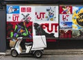 japanese three-wheeled motorcycle parked in front of posters featuring anime characters.