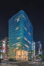 Louis Vuitton Ginza store fully covered of holographic glass with emerald blue highlights at night.